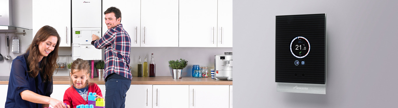 Photo of couple in a kitchen talking with a boiler.
