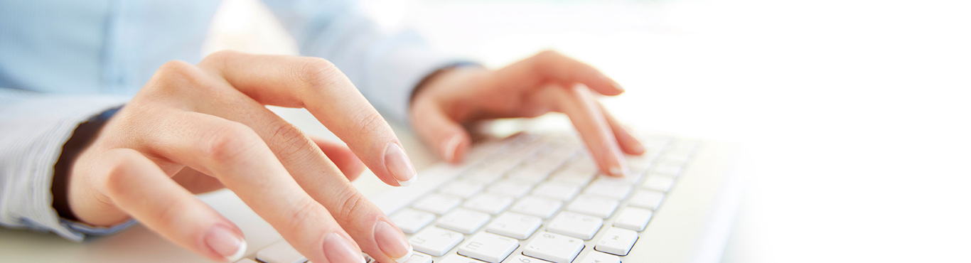 Close up photo of a person's hands typing.